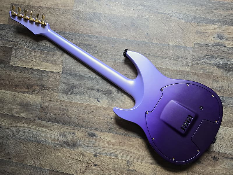 Purple synthetic electric guitar on a wooden floor