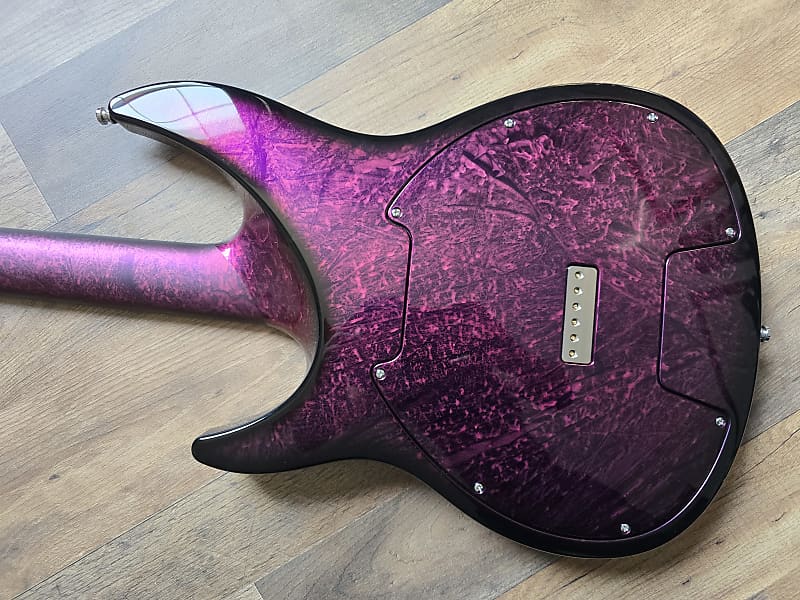 Purple and black guitar body on a wooden floor