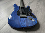 Blue electric guitar with a black pickguard lying on a wooden surface