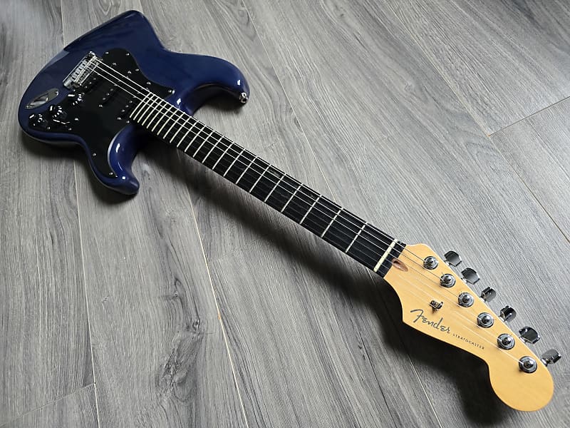 Blue Fender Stratocaster featuring an ash wood body, maple neck, and ebony fretboard