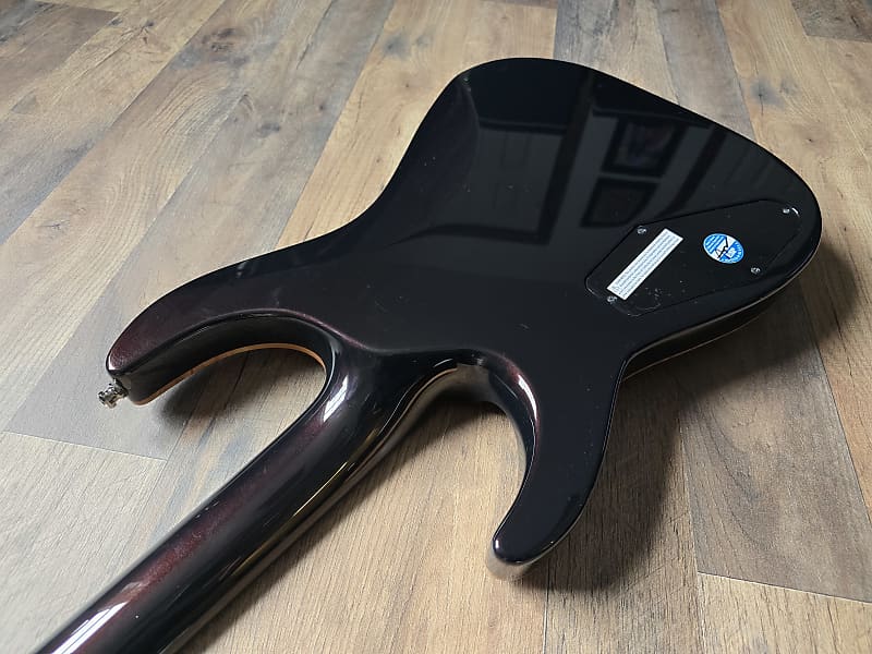 Black guitar neck on a wooden floor