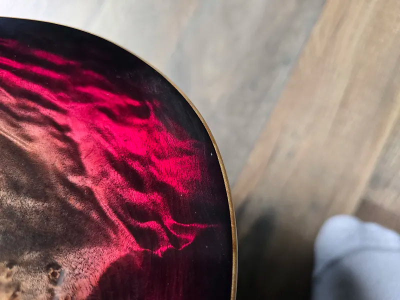 Close-up of a guitar with a red and black pattern on the body.
