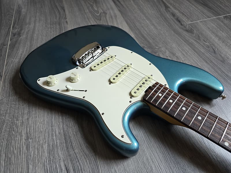 Blue and white electric guitar on a wooden floor