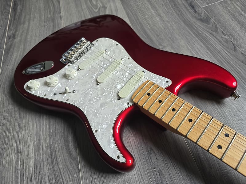Red electric guitar with white pickups and knobs