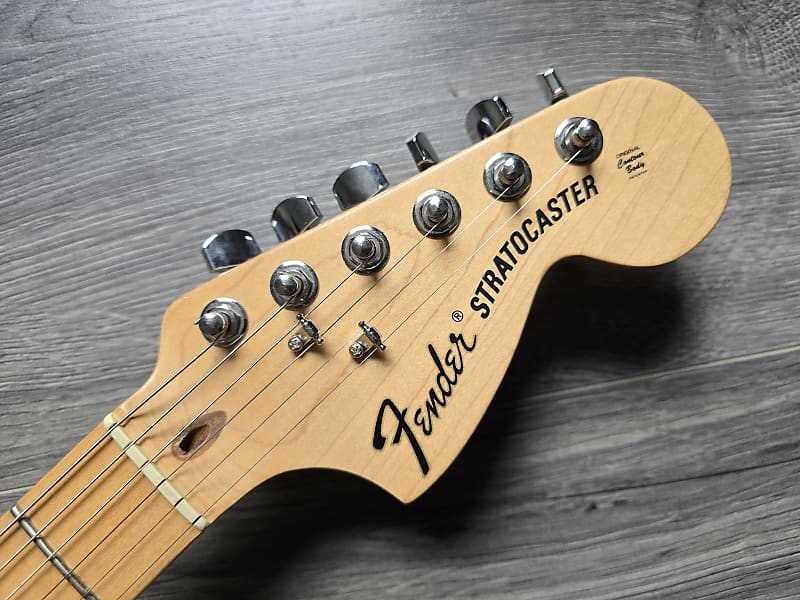Fender Stratocaster guitar headstock on a wooden surface