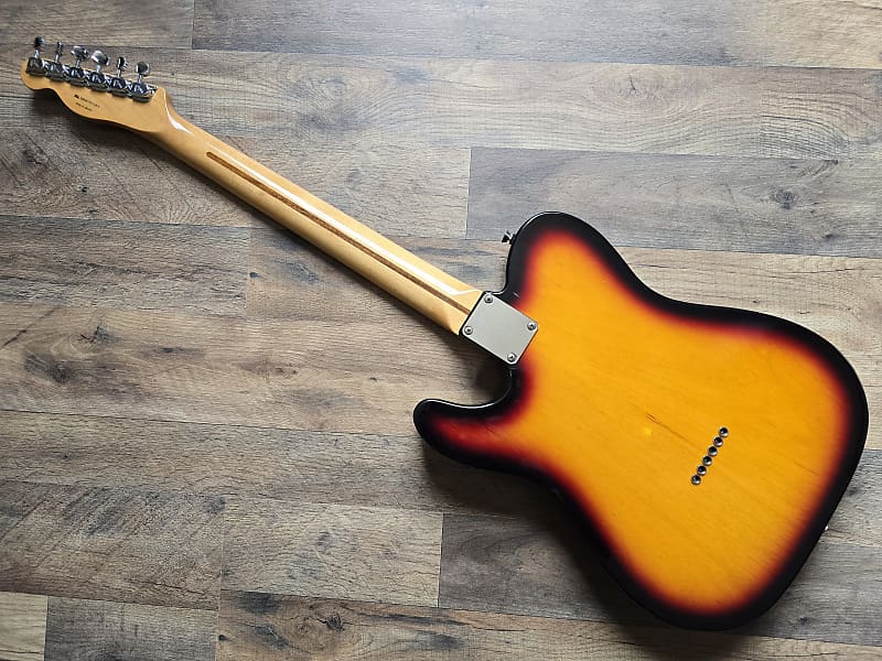 Electric guitar with sunburst finish on a wooden floor