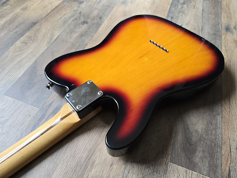 Electric guitar body with sunburst finish on a wooden floor