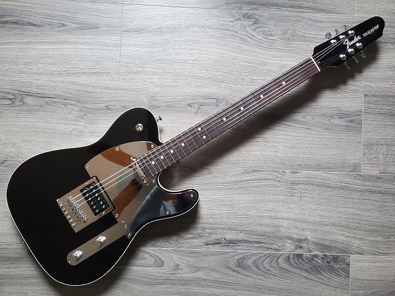 A black Fender Custom Shop John 5 HB Telecaster electric guitar with a rosewood fretboard and a steel pickguard, laid on a wooden floor.