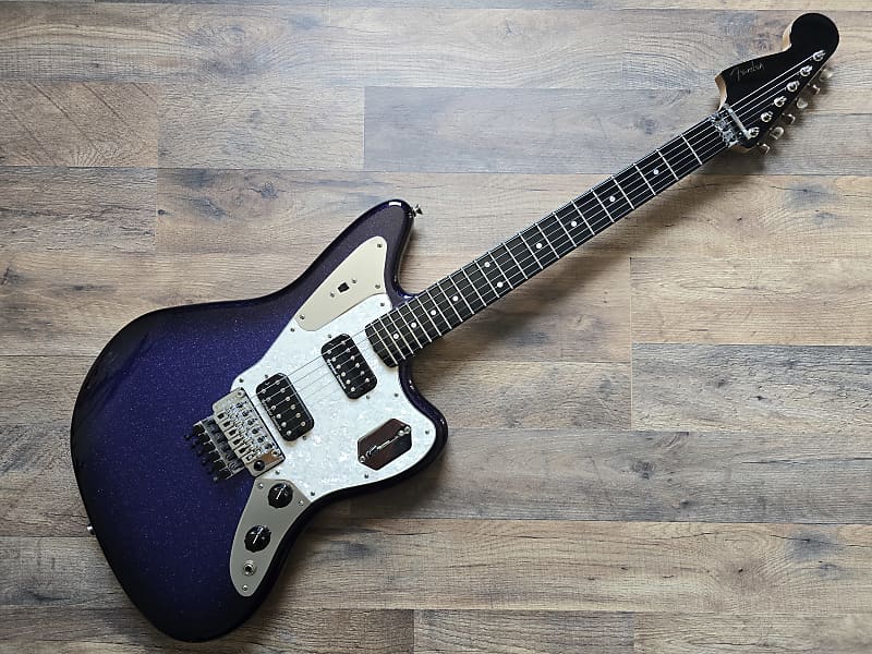 Electric guitar with a blue and white design on a wooden surface