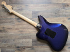 Blue electric guitar body with a maple neck on a wooden floor