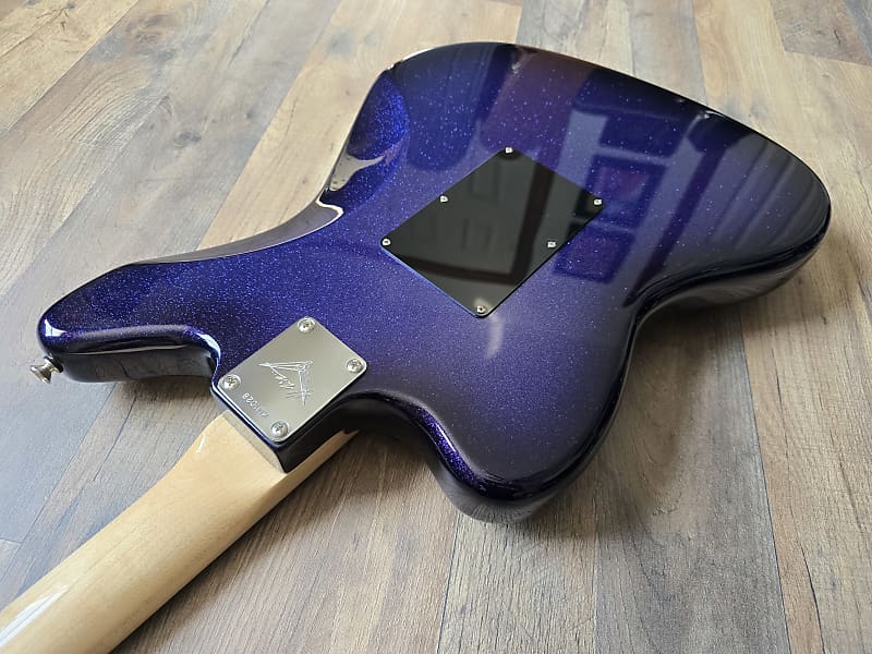 Guitar body with a blue glitter finish on a wooden surface