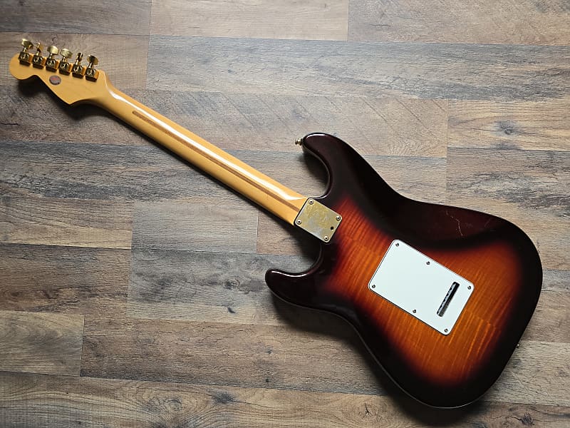 Red and black electric guitar on a wooden floor