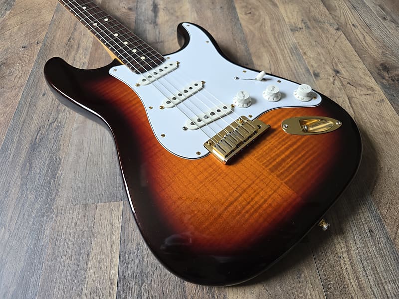 Electric guitar with a sunburst finish on a wooden surface