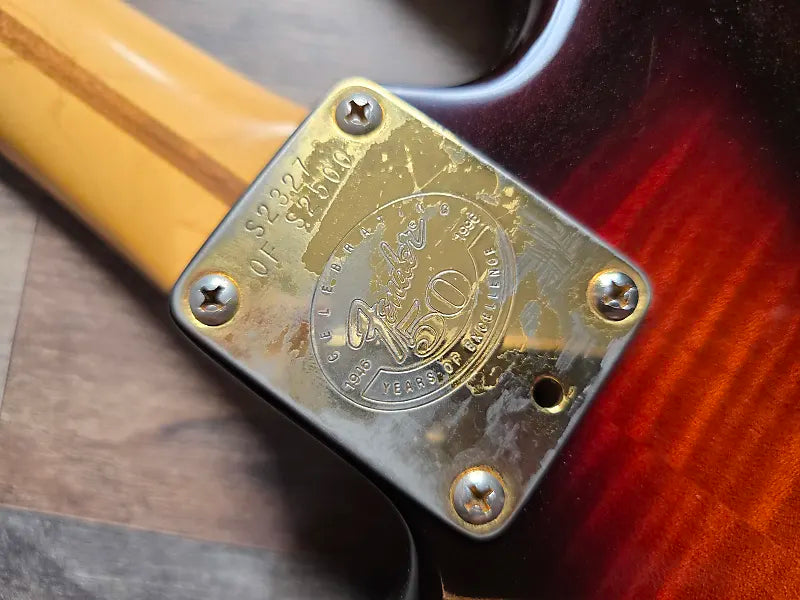 Close-up of a vintage Fender brand logo on a wooden neck