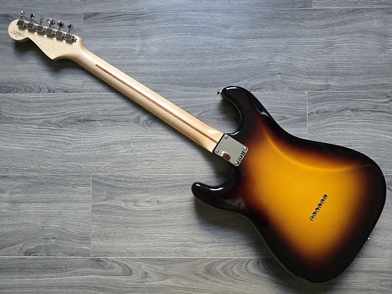 Electric guitar with sunburst finish on a wooden surface