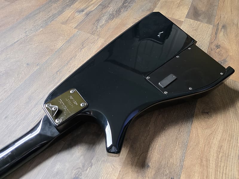 Black guitar body on a wooden floor