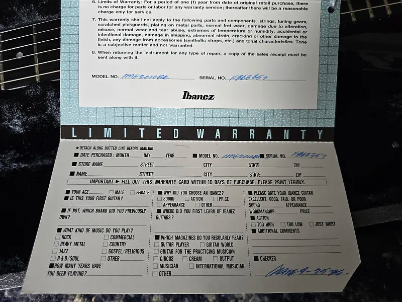 Ibanez guitar with warranty card and guitar neck in the background