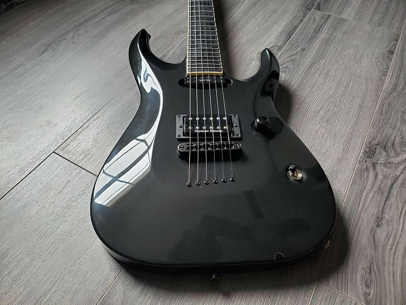 Black electric guitar with Seymour Duncan pickups on a wooden surface