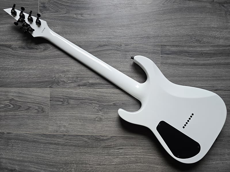 White back of an electric guitar on a wooden surface