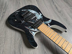 Black electric guitar with white design and maple fretboard