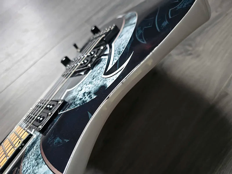 Close-up of a guitar with a textured body on a wooden surface