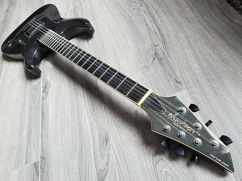 Black Jackson guitar on a wooden floor