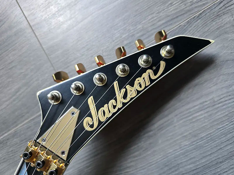 Jackson guitar headstock on a wooden surface