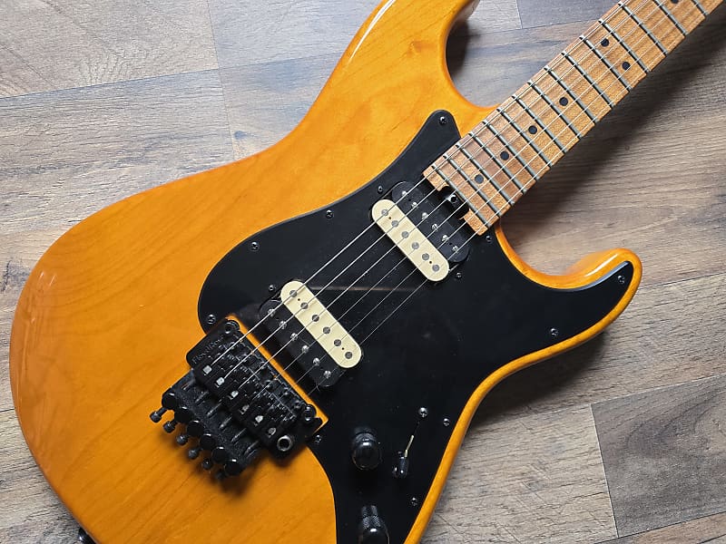 Orange and black electric guitar with black pickups and hardware