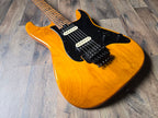 Electric guitar with an orange alder body on a wooden surface