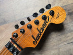 Close-up of a Jackson guitar headstock on a wooden surface