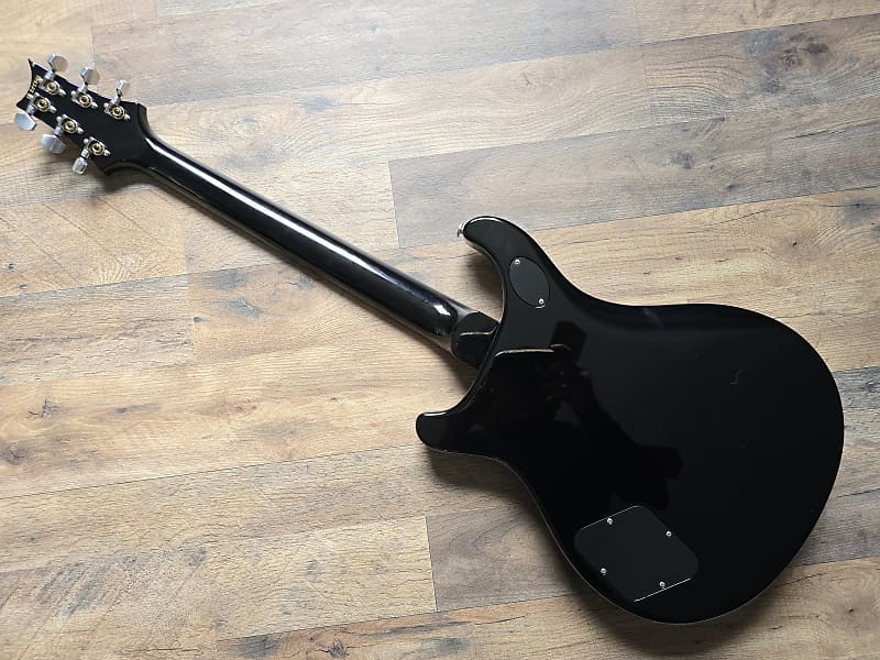 Black electric guitar on a wooden floor