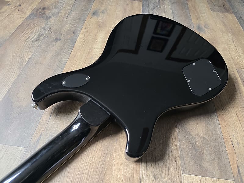 Black electric guitar body on a wooden floor
