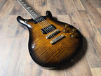 Electric guitar with a yellow flamed maple top on a wooden floor