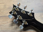Black guitar headstock with tuning pegs and serial number