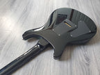 Black electric guitar body on a wooden floor