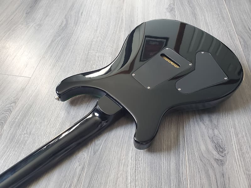 Black electric guitar body on a wooden floor