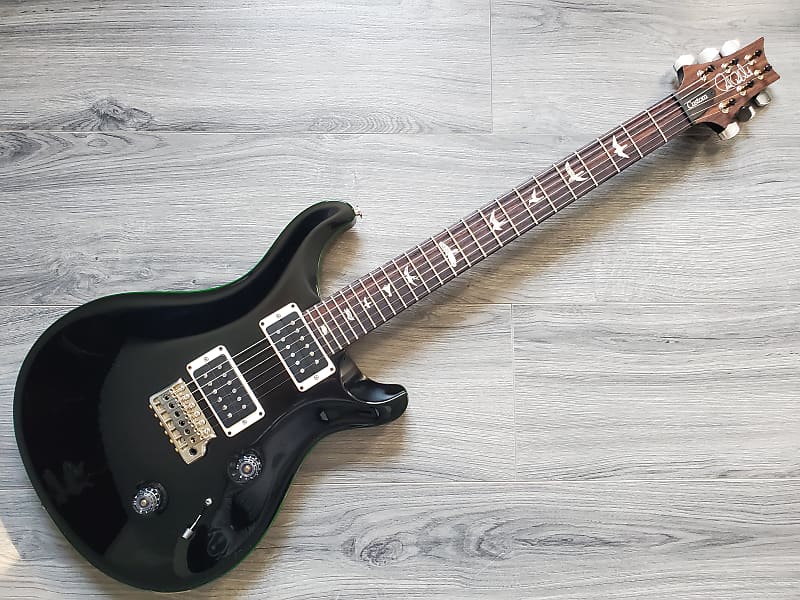 Black PRS Custom 24 electric guitar on a wooden surface