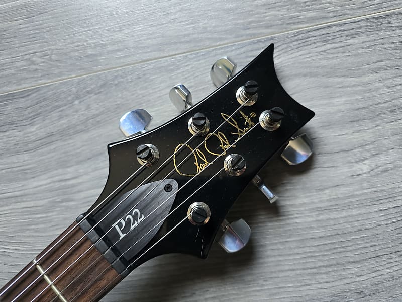 Guitar headstock with 'P22' branding on a wooden surface