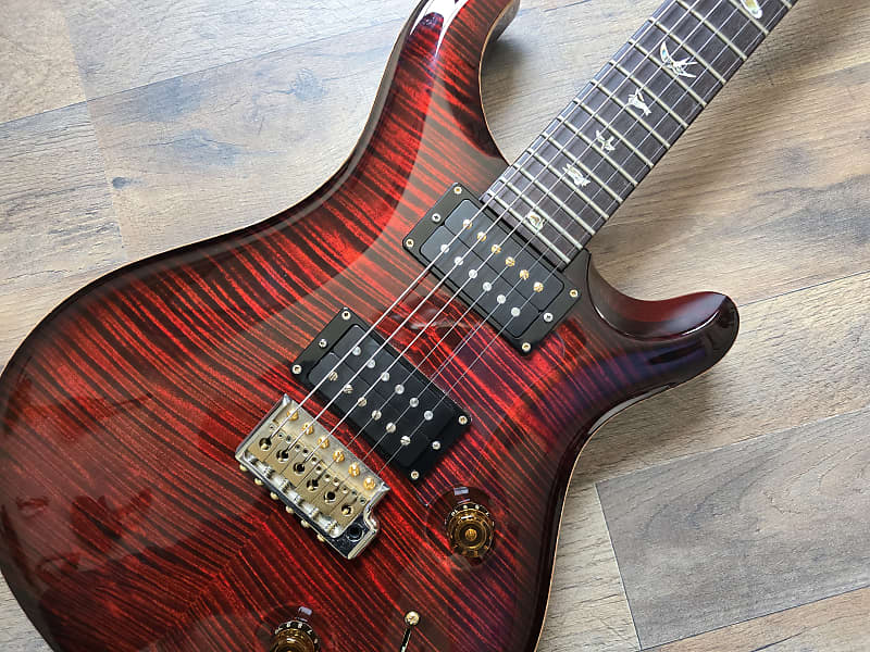 Electric guitar with a red and black finish on a wooden surface