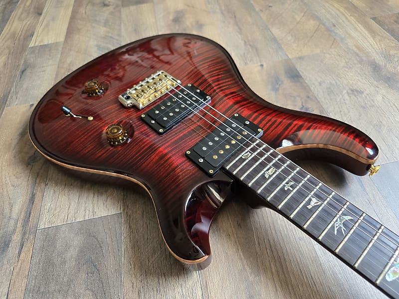 Red electric guitar with a rosewood fretboard, PRS locking tuners and pickups