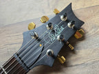 Black guitar headstock with gold tuning pegs and 'Paul Reed Smith' branding