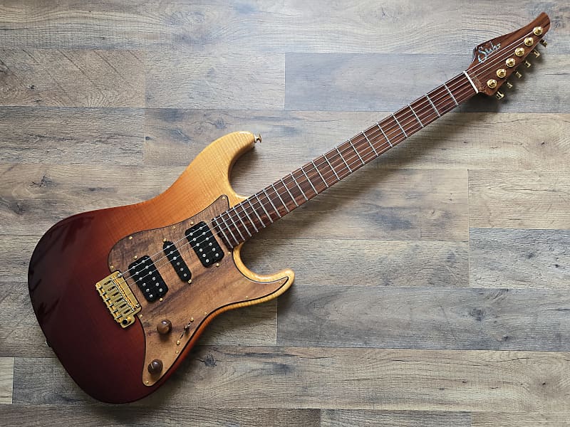 Suhr electric guitar with a sunburst finish on a wooden surface
