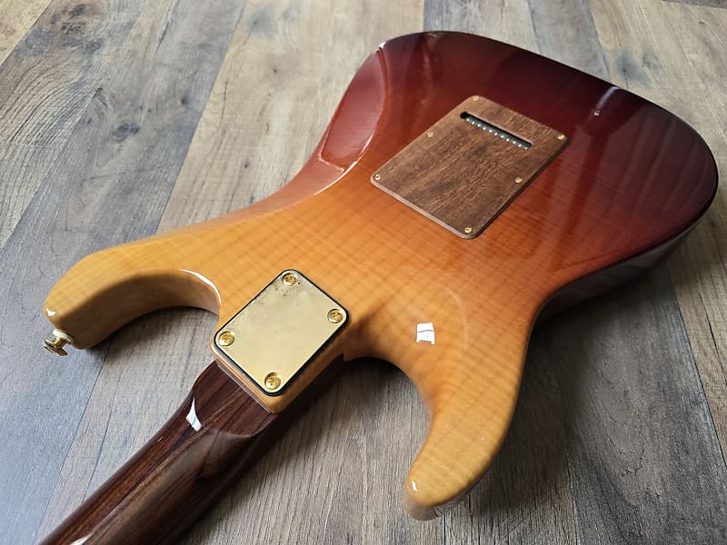Guitar body with a brown finish on a wooden surface