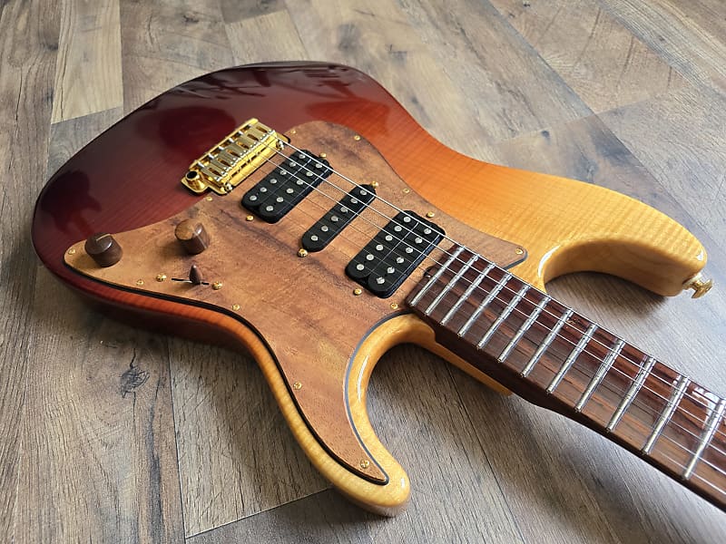 Flamed maple guitar body with a sunburst finish and black pickups