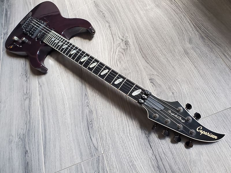 Crimson Caparison electric guitar with a Gotoh Floyd Rose lying on a wooden surface.