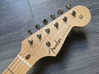 Fender Stratocaster guitar headstock on a wooden surface
