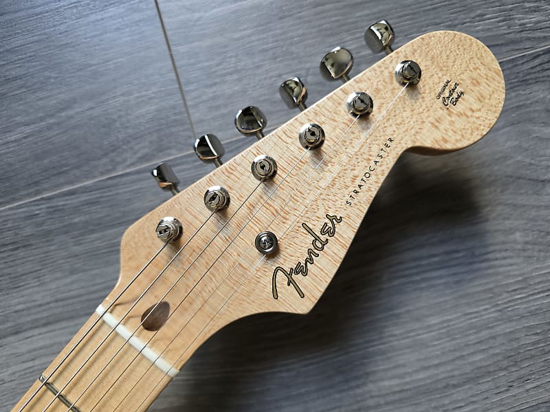 Fender Stratocaster guitar headstock on a wooden surface