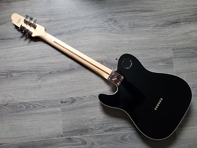 Black vintage style Fender guitar face down on a wooden surface