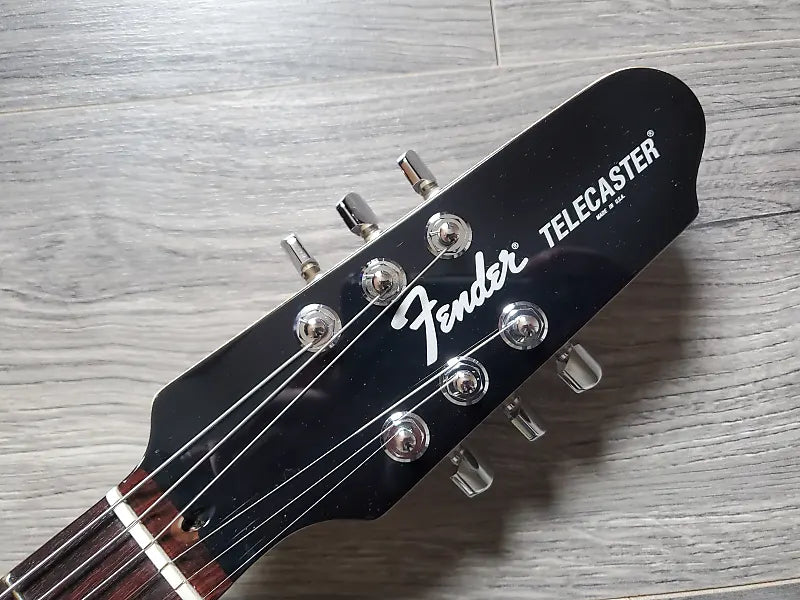 Fender Telecaster guitar headstock on a wooden surface