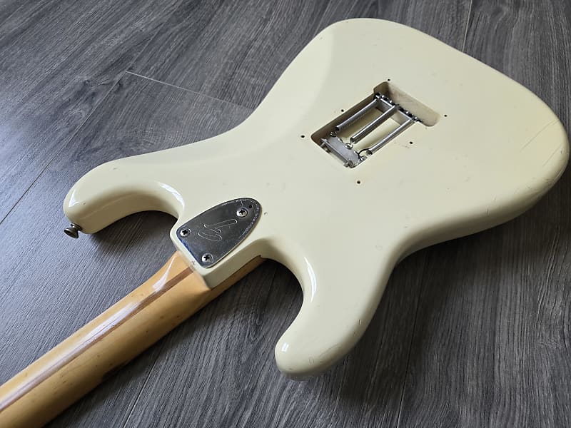White electric guitar body on a gray wooden surface
